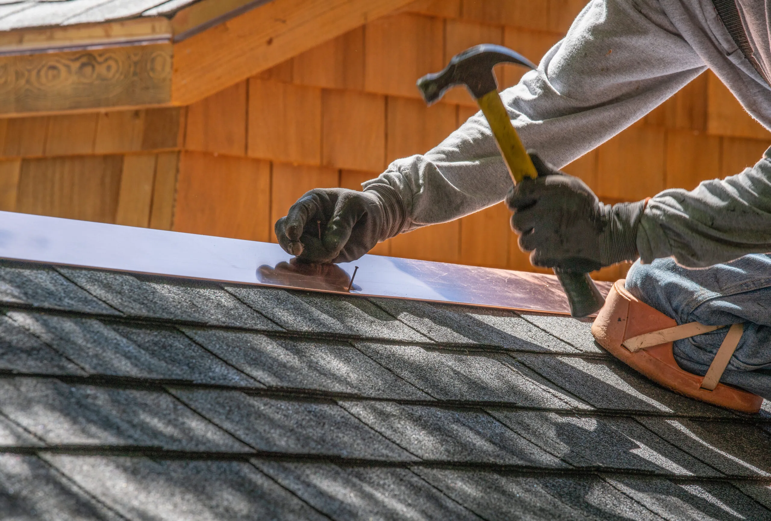 Man installing asphalt roof.